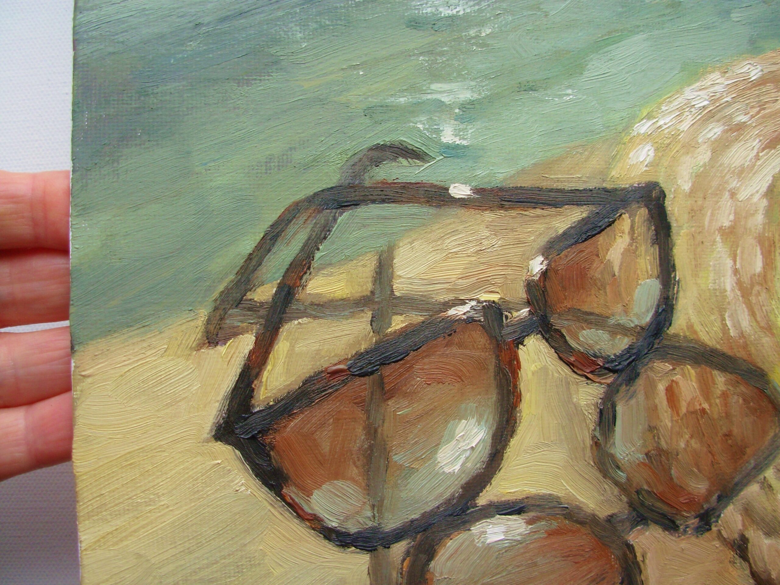 Close-up of the sunglasses and straw hat at the water's edge in Summer Accessories by Elena Ivanova-Batacharia.